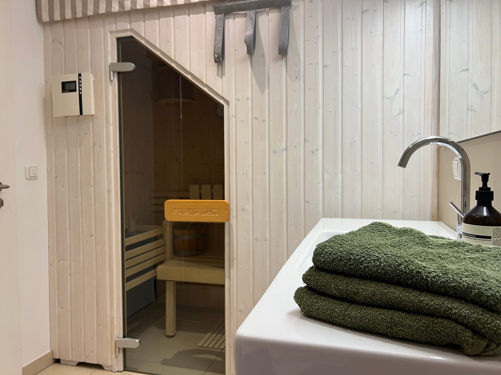Eigene Sauna aus hellem Holz im Duschbad